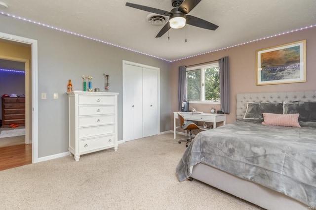 bedroom with ceiling fan, light carpet, and a closet