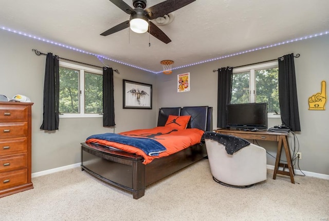 carpeted bedroom with multiple windows and ceiling fan