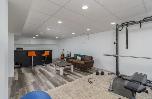 workout room with a paneled ceiling and wood-type flooring