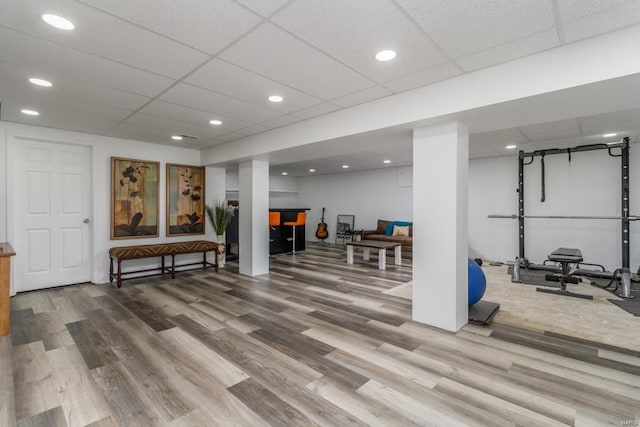 exercise area featuring hardwood / wood-style floors and a paneled ceiling