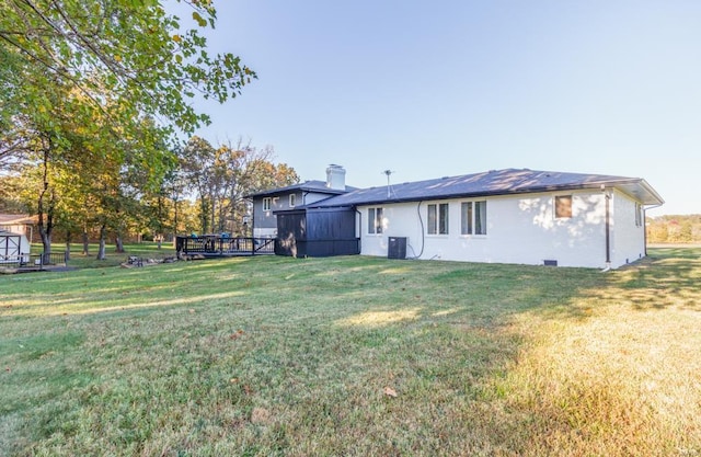 back of property with a lawn and central AC