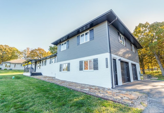 view of property exterior featuring a garage and a lawn