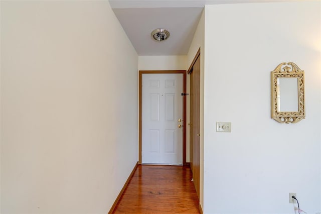 hallway with hardwood / wood-style flooring