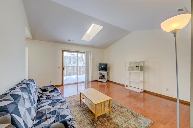 living room featuring lofted ceiling with skylight and hardwood / wood-style floors