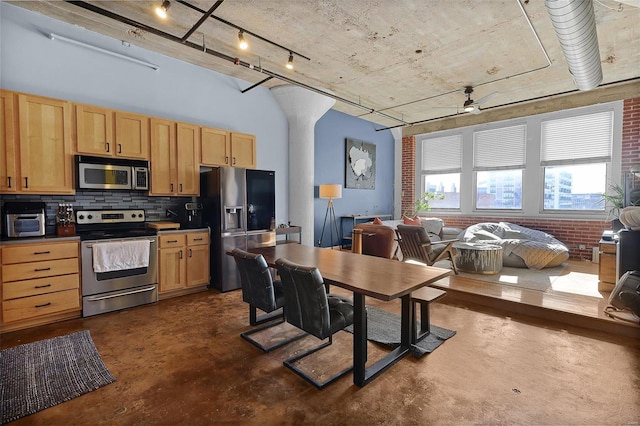 kitchen with brick wall, stainless steel appliances, tasteful backsplash, light brown cabinetry, and ceiling fan