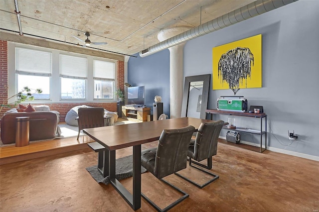 dining room with ceiling fan, brick wall, and concrete floors