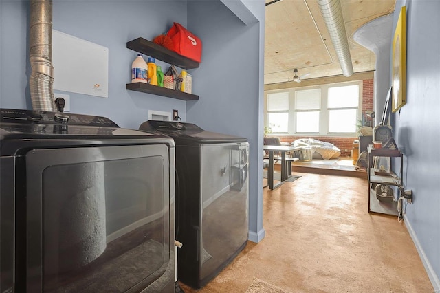 clothes washing area featuring washing machine and dryer, brick wall, and light colored carpet