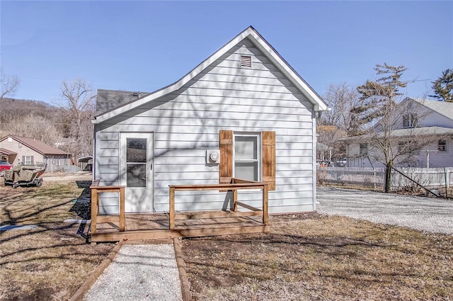 rear view of property featuring fence