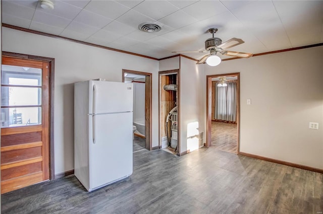 kitchen with ornamental molding, freestanding refrigerator, visible vents, and wood finished floors