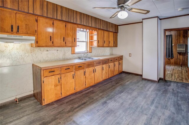 kitchen featuring under cabinet range hood, dark wood finished floors, light countertops, and a sink