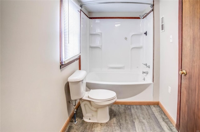 full bathroom with baseboards, shower / tub combination, toilet, and wood finished floors