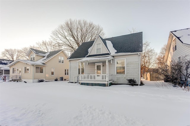 snow covered property featuring cooling unit and a porch