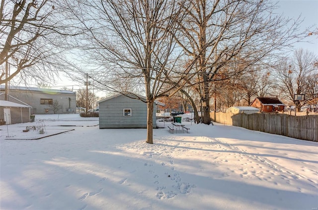 snowy yard featuring an outbuilding