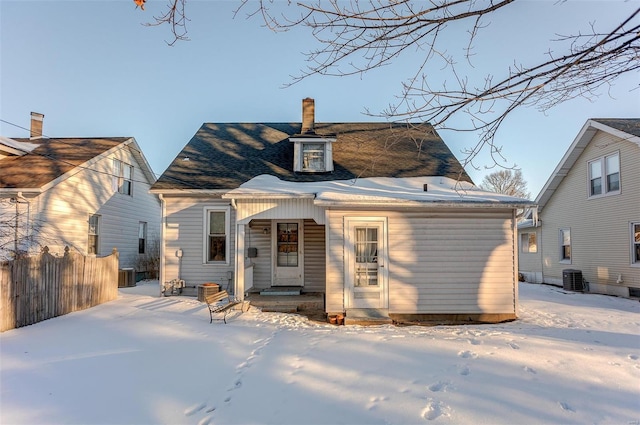 snow covered house with central AC unit