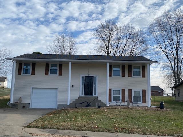 raised ranch with a front yard and a garage