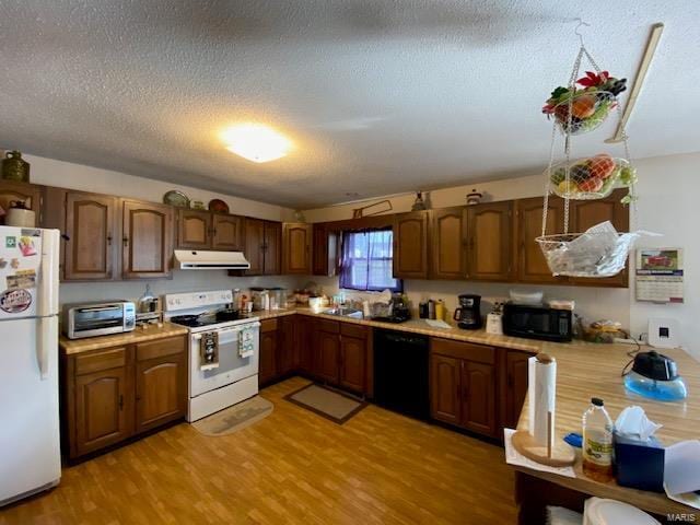 kitchen featuring black appliances, light hardwood / wood-style flooring, sink, and a textured ceiling