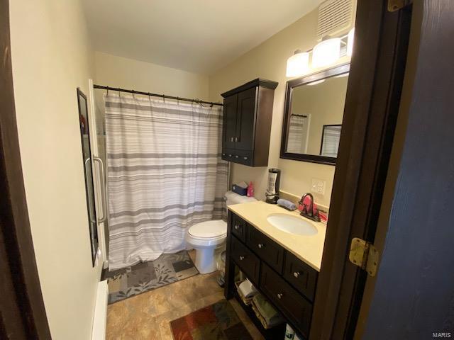 bathroom featuring a shower with curtain, vanity, and toilet