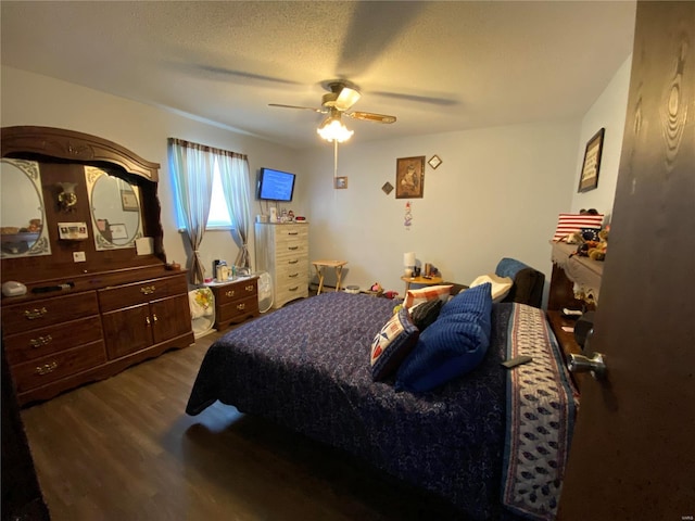 bedroom featuring a textured ceiling, ceiling fan, and dark hardwood / wood-style flooring