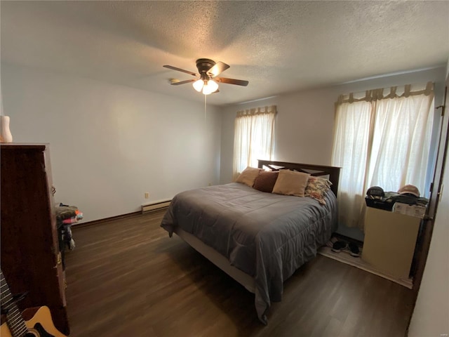 bedroom with ceiling fan, dark wood-type flooring, a baseboard radiator, and a textured ceiling