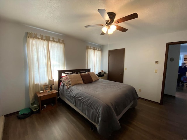 bedroom featuring ceiling fan, dark wood-type flooring, and a textured ceiling