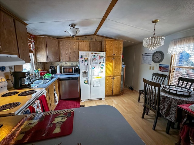 kitchen with pendant lighting, sink, light hardwood / wood-style floors, lofted ceiling, and stainless steel appliances