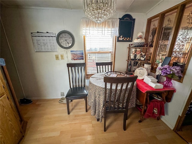 dining space featuring light wood-type flooring and a chandelier