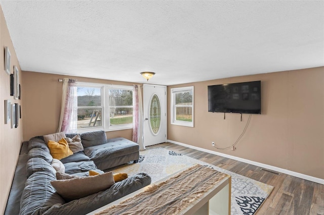 living room with dark hardwood / wood-style flooring and a textured ceiling