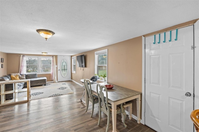 dining area featuring a textured ceiling and dark hardwood / wood-style flooring