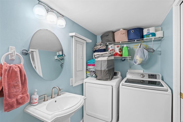 clothes washing area with washing machine and dryer and sink