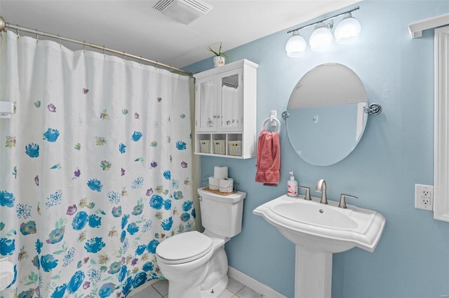 bathroom with toilet, curtained shower, and tile patterned floors