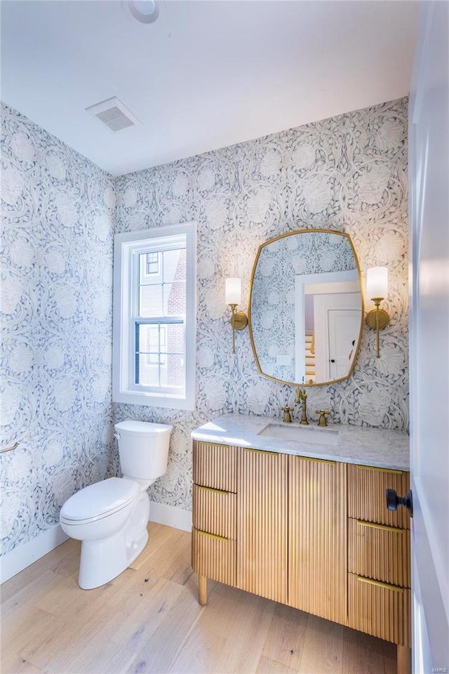 bathroom featuring vanity, hardwood / wood-style floors, and toilet