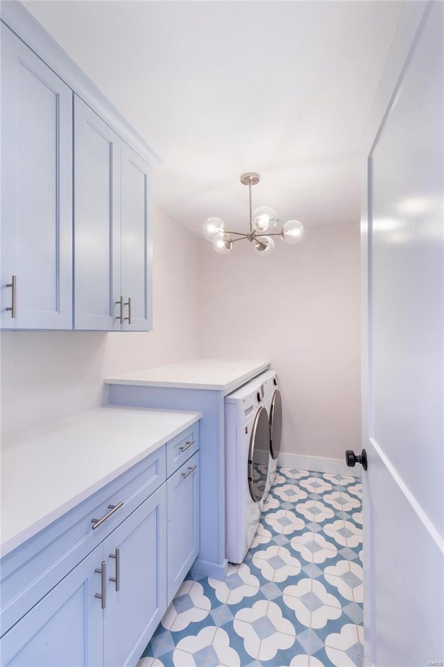 laundry room featuring cabinets, separate washer and dryer, and a notable chandelier