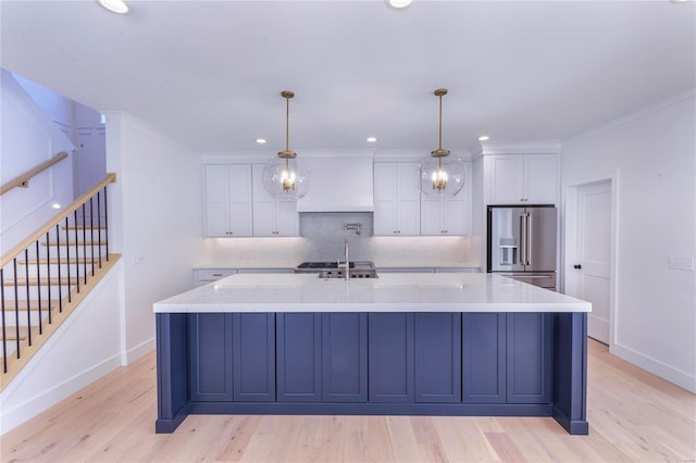 kitchen with pendant lighting, tasteful backsplash, white cabinets, a large island, and high end fridge