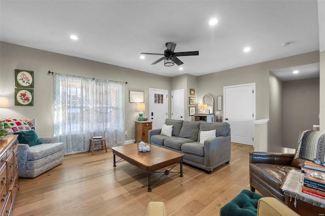 living room featuring ceiling fan and light hardwood / wood-style flooring