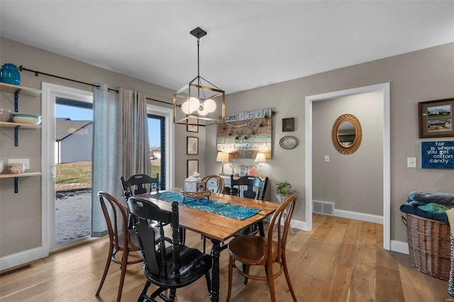 dining room with a chandelier and light wood-type flooring