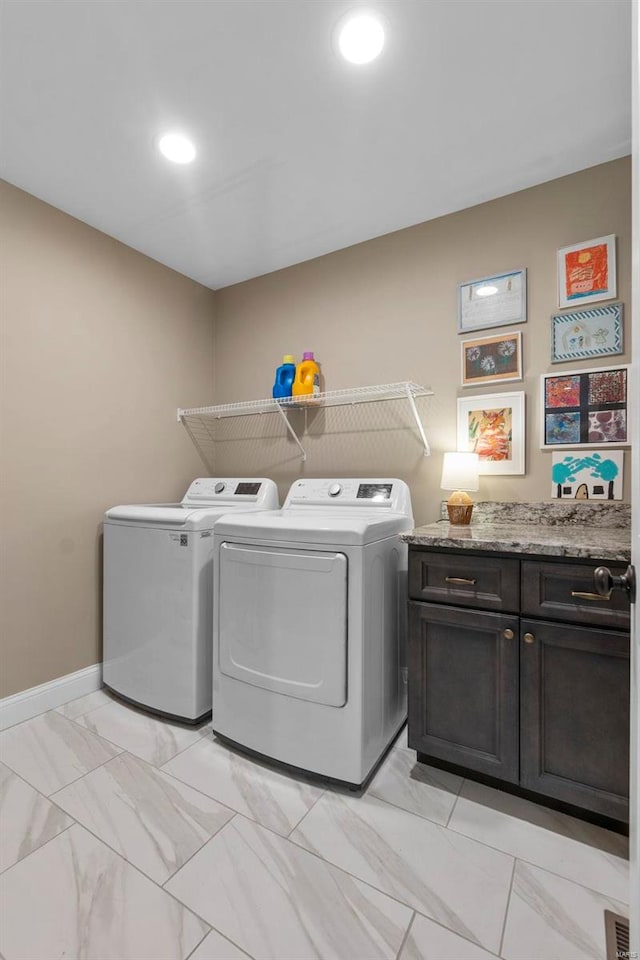 laundry area featuring washing machine and dryer and cabinets