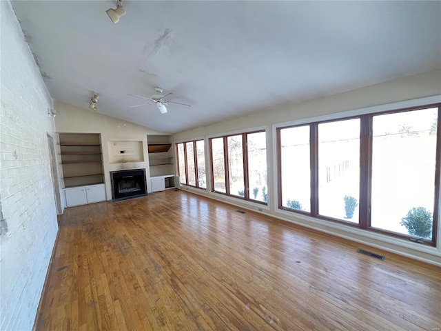 unfurnished living room featuring ceiling fan, lofted ceiling, and light wood-type flooring