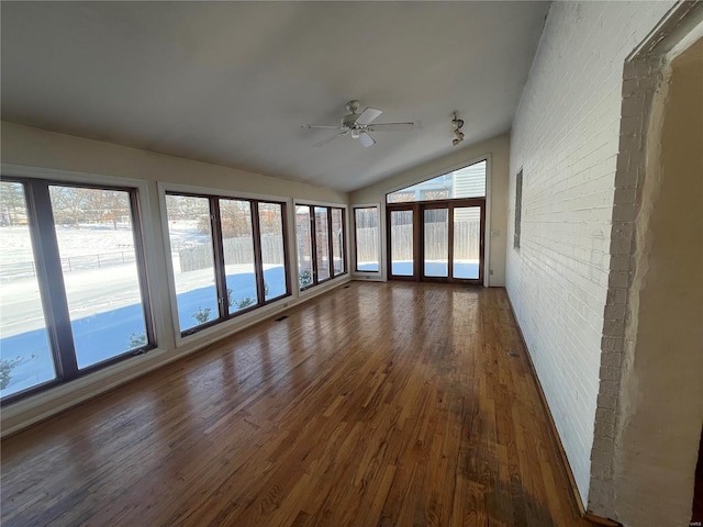 unfurnished sunroom featuring lofted ceiling, plenty of natural light, and ceiling fan