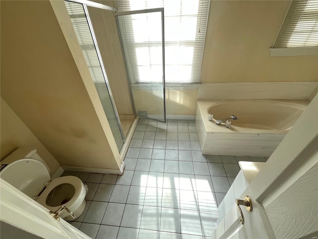 bathroom with tile patterned floors, toilet, and separate shower and tub