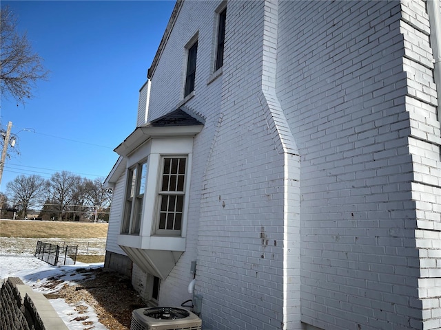 snow covered property with central AC unit