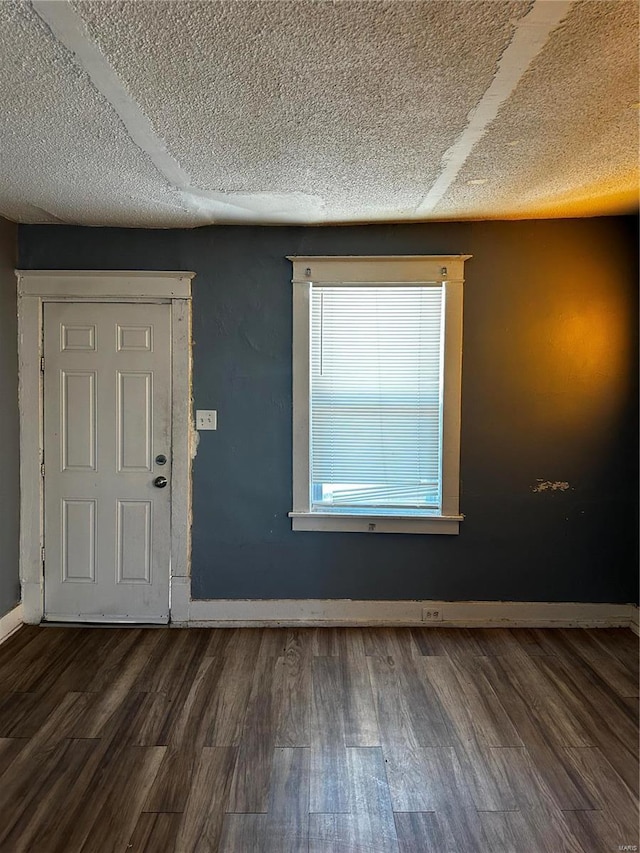 foyer entrance featuring a textured ceiling and dark hardwood / wood-style flooring