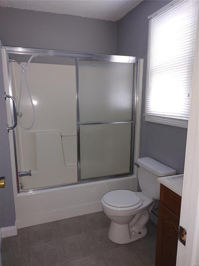 full bathroom with vanity, toilet, and combined bath / shower with glass door