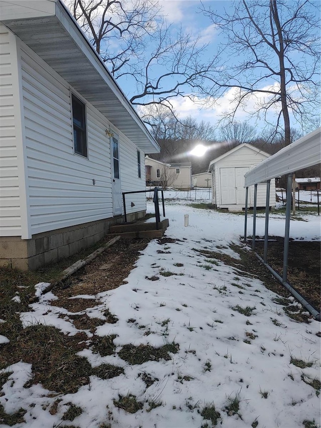 view of snowy exterior with a shed