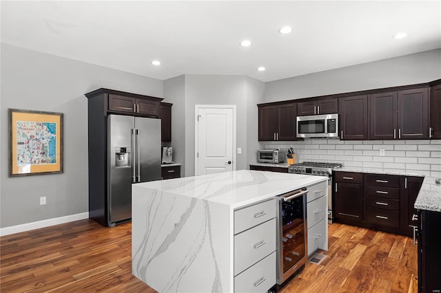 kitchen featuring light stone countertops, a center island, wine cooler, and high quality appliances