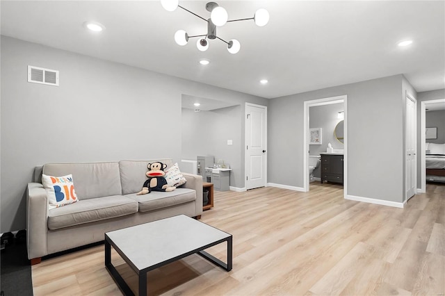 living room featuring light hardwood / wood-style flooring and a notable chandelier