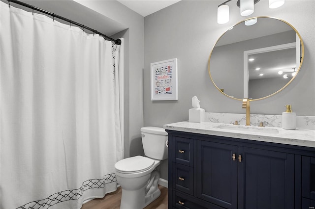 bathroom with hardwood / wood-style floors, vanity, and toilet