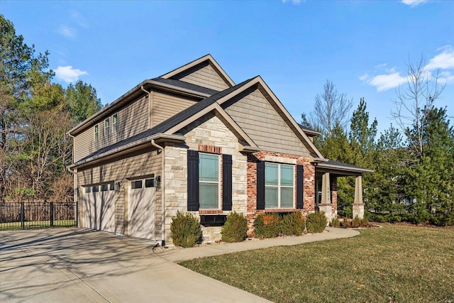 view of front of house with a front yard, fence, concrete driveway, a garage, and stone siding