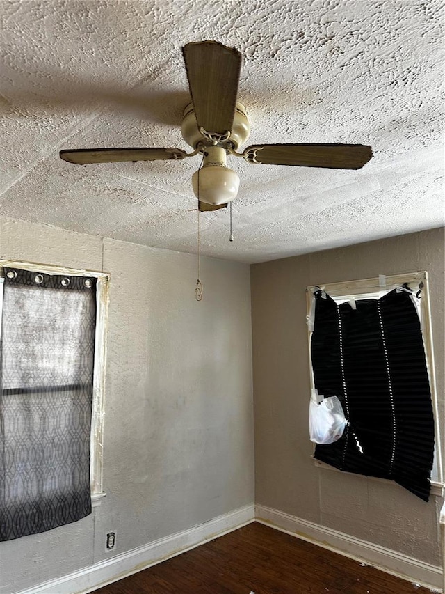 unfurnished room featuring a textured ceiling, ceiling fan, and dark hardwood / wood-style floors