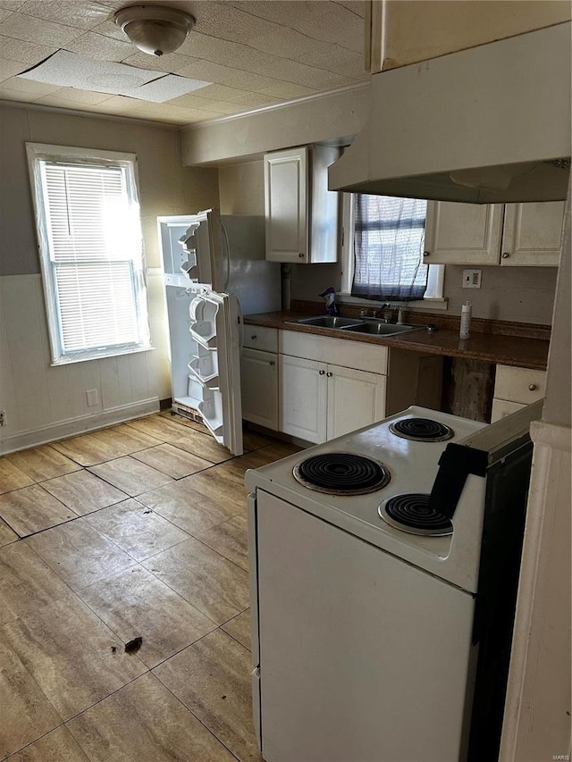 kitchen featuring sink, white cabinetry, white electric stove, and range hood