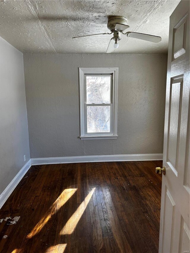 empty room featuring ceiling fan, dark hardwood / wood-style flooring, and a textured ceiling